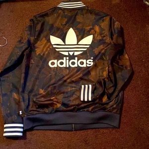 Adidas jacket that has brown leaves on them